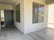 Covered porch with neutral walls, a glass paneled entry door, and dual pane windows at 17477 W Woodrow Ln, Surprise, AZ 85388