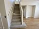 Carpeted staircase with handrail and modern lighting leads to the upper level at 17477 W Woodrow Ln, Surprise, AZ 85388