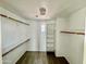 Spacious walk-in closet with white walls and built-in shelves with a small window for natural light at 17477 W Woodrow Ln, Surprise, AZ 85388