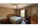 Carpeted bedroom features a ceiling fan and natural light from a large window at 19058 N Aztec Point Dr, Surprise, AZ 85387