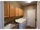 Laundry room features overhead cabinets, a utility sink and a side-by-side washer and dryer at 19058 N Aztec Point Dr, Surprise, AZ 85387