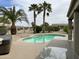 Sparkling backyard pool surrounded by mature palm trees and lush desert landscaping at 19058 N Aztec Point Dr, Surprise, AZ 85387