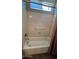 Bathroom featuring a shower-tub combo with neutral tile surround and shower curtain at 19058 N Aztec Point Dr, Surprise, AZ 85387