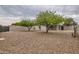 Large gravel backyard featuring mature trees, a block wall and a covered patio area at 2021 W Clarendon Ave, Phoenix, AZ 85015