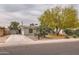 Single-story home with desert landscaping, including mature trees and native cacti at 2021 W Clarendon Ave, Phoenix, AZ 85015