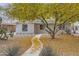 Single-story home with desert landscaping, including mature trees and native cacti at 2021 W Clarendon Ave, Phoenix, AZ 85015