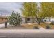 Charming single-story home featuring desert landscaping, mature tree, and a welcoming walkway at 2021 W Clarendon Ave, Phoenix, AZ 85015