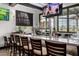 Upscale bar area featuring a full bar, multiple taps, TVs, and seating with a golf course view at 22318 N Pico Ct, Sun City West, AZ 85375