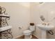 Powder room featuring pedestal sink, decorative mirror and fixtures, and tile flooring at 22318 N Pico Ct, Sun City West, AZ 85375