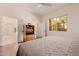 Cozy bedroom boasts natural light, a ceiling fan, and a decorative media center at 22318 N Pico Ct, Sun City West, AZ 85375