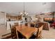 Open-concept living featuring a dining area with a wooden table and chairs overlooking kitchen and living room at 22318 N Pico Ct, Sun City West, AZ 85375