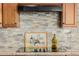 Modern kitchen features stone backsplash, granite countertops and sleek stovetop for a stylish cooking experience at 22318 N Pico Ct, Sun City West, AZ 85375