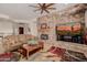 Inviting living room featuring a stunning stone fireplace, comfortable seating, and a decorative coffee table at 22318 N Pico Ct, Sun City West, AZ 85375