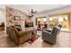 Cozy living room boasts a striking stone fireplace, comfortable seating, and views of a pool and backyard at 22318 N Pico Ct, Sun City West, AZ 85375
