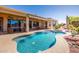 Backyard oasis featuring a sparkling pool, covered patio, and lush landscaping perfect for outdoor living at 22318 N Pico Ct, Sun City West, AZ 85375