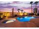 Sparkling pool and spa surrounded by lush landscaping and decorative wall art under a colorful evening sky at 22318 N Pico Ct, Sun City West, AZ 85375