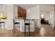 Entertainer's wet bar features granite countertops, stylish seating, and views of a home office at 22318 N Pico Ct, Sun City West, AZ 85375