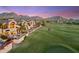 Stunning aerial view of homes on the golf course against a colorful desert mountain sunset at 25150 N Windy Walk Dr # 37, Scottsdale, AZ 85255