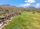 Scenic aerial view of a golf course community with homes nestled among lush green fairways and mountain views at 25150 N Windy Walk Dr # 37, Scottsdale, AZ 85255