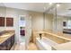Well-lit bathroom with marble floors, bathtub, dark wood cabinets, and a doorway to a bedroom at 25150 N Windy Walk Dr # 37, Scottsdale, AZ 85255