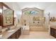 Elegant bathroom with a soaking tub, glass-enclosed shower, and a large mirror at 25150 N Windy Walk Dr # 37, Scottsdale, AZ 85255