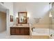 The bright bathroom offers a soaking tub, vanity with a sink, and a decorative mirror at 25150 N Windy Walk Dr # 37, Scottsdale, AZ 85255