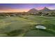 Picturesque golf course with green grass, a sand trap, and desert mountain views at 25150 N Windy Walk Dr # 37, Scottsdale, AZ 85255