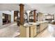 Open-concept kitchen featuring granite counters, wooden columns, wine cooler, and views to the living room at 25150 N Windy Walk Dr # 37, Scottsdale, AZ 85255