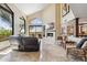 Spacious living room boasts soaring ceilings, large windows, a fireplace, and views of the outdoor patio at 25150 N Windy Walk Dr # 37, Scottsdale, AZ 85255
