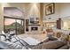 Living room with fireplace, clerestory windows, and sliding door to backyard featuring desert and sunset views at 25150 N Windy Walk Dr # 37, Scottsdale, AZ 85255