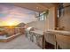 Outdoor kitchen with stone counter, grill, seating, and mountain views at sunset at 25150 N Windy Walk Dr # 37, Scottsdale, AZ 85255