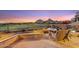 Back patio with desert landscaping, fire pit, and views of the golf course and Pinnacle Peak at sunset at 25150 N Windy Walk Dr # 37, Scottsdale, AZ 85255