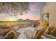 Back patio with lounge chairs, desert landscaping, fire pit, and views of Pinnacle Peak at sunset at 25150 N Windy Walk Dr # 37, Scottsdale, AZ 85255