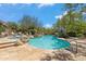 Resort-style pool with a spa, rock features, lush landscaping, and inviting lounge areas at 25150 N Windy Walk Dr # 37, Scottsdale, AZ 85255