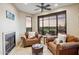 Sitting room with two armchairs, fireplace, ceiling fan, and desert views from the large windows at 25150 N Windy Walk Dr # 37, Scottsdale, AZ 85255