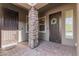 Exterior entryway featuring a stone pillar, two ornate doors and a paver patio at 28623 N 66Th Ave, Phoenix, AZ 85083