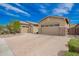 Exterior view of a desert home with a three-car garage and a paver driveway at 28623 N 66Th Ave, Phoenix, AZ 85083
