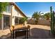 Paver patio with a wood outdoor dining set, desert landscaping, and large windows at 302 E Acapulco Ln, Phoenix, AZ 85022
