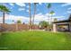 Expansive backyard features lush green lawn, patio with dining set, and mature landscaping at 302 E Acapulco Ln, Phoenix, AZ 85022