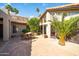 Backyard paver patio with modern outdoor dining set, tall windows, and desert landscaping at 302 E Acapulco Ln, Phoenix, AZ 85022
