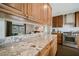 Open kitchen with granite countertops, stainless steel appliances, and dark wood cabinetry at 302 E Acapulco Ln, Phoenix, AZ 85022