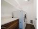 Convenient laundry room featuring a countertop, wooden cabinets, and modern washer and dryer at 302 E Acapulco Ln, Phoenix, AZ 85022