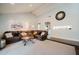Open-concept living room boasts a vaulted ceiling, comfortable leather seating, and neutral carpeting at 302 E Acapulco Ln, Phoenix, AZ 85022