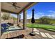 Covered backyard patio with wood floors, furniture, and a built-in putting green for outdoor entertaining at 3601 N Sonoran Hts, Mesa, AZ 85207