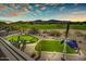 Expansive backyard at dusk, featuring a putting green and lush landscaping with views at 3601 N Sonoran Hts, Mesa, AZ 85207