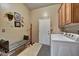 Functional laundry room with washer, dryer, and storage cabinets with a seating area and decorated wall at 3601 N Sonoran Hts, Mesa, AZ 85207