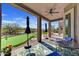 Covered outdoor patio with ceiling fan and putting green at 3601 N Sonoran Hts, Mesa, AZ 85207