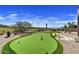 Landscaped backyard featuring a professional-grade putting green with manicured grounds under a sunny sky at 3601 N Sonoran Hts, Mesa, AZ 85207