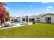 Outdoor living area showcasing a swimming pool, manicured lawn, and stylish outdoor furniture at 3710 E Hazelwood St, Phoenix, AZ 85018