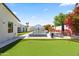 Backyard with a modern pool, artificial putting green and manicured lawn for outdoor entertaining at 3710 E Hazelwood St, Phoenix, AZ 85018